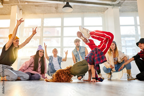 young teens dancing hip-hop in stylish clothes in light studio background. youth culture, movement, style and fashion, action