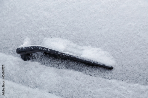 car rear windshield and wiper waterblade frozen and covered with snow at winter cloudy day light photo