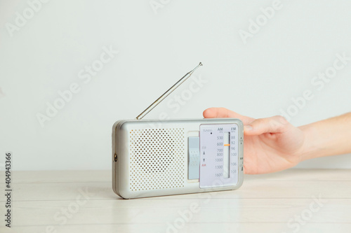 A hand on an old radio on a white background. Radio concept. Vintage style.