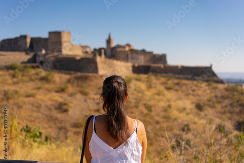Caucasian woman looking at Juromenha castle on a summer day in Alentejo, Portugal photo