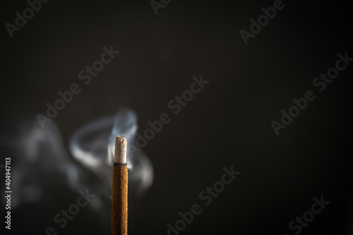 Asian incense stick burning with smoke, close up, macro