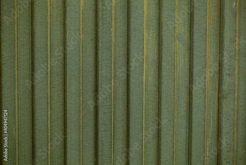 Background texture of decorative fluted green cladding in a repeat vertical pattern in a full frame view. This is a lighter version, a darker version is also available in the portfolio photo
