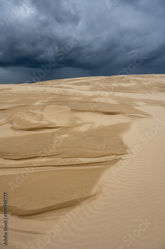 Stockton sand dunes with dark stormy sky in the background