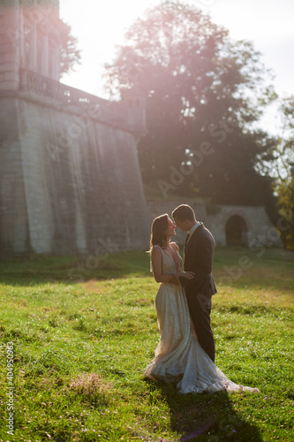 Beautiful bride and goom standing together in front of old palace. Wedding couple. Wedding photo photo