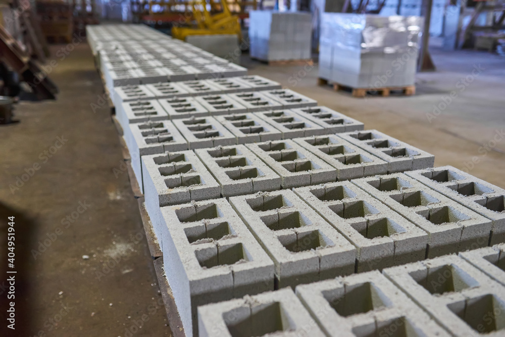 Fototapeta premium Industrial production of building materials from pressed cement mortar. High quality hollow concrete block or cement brick.