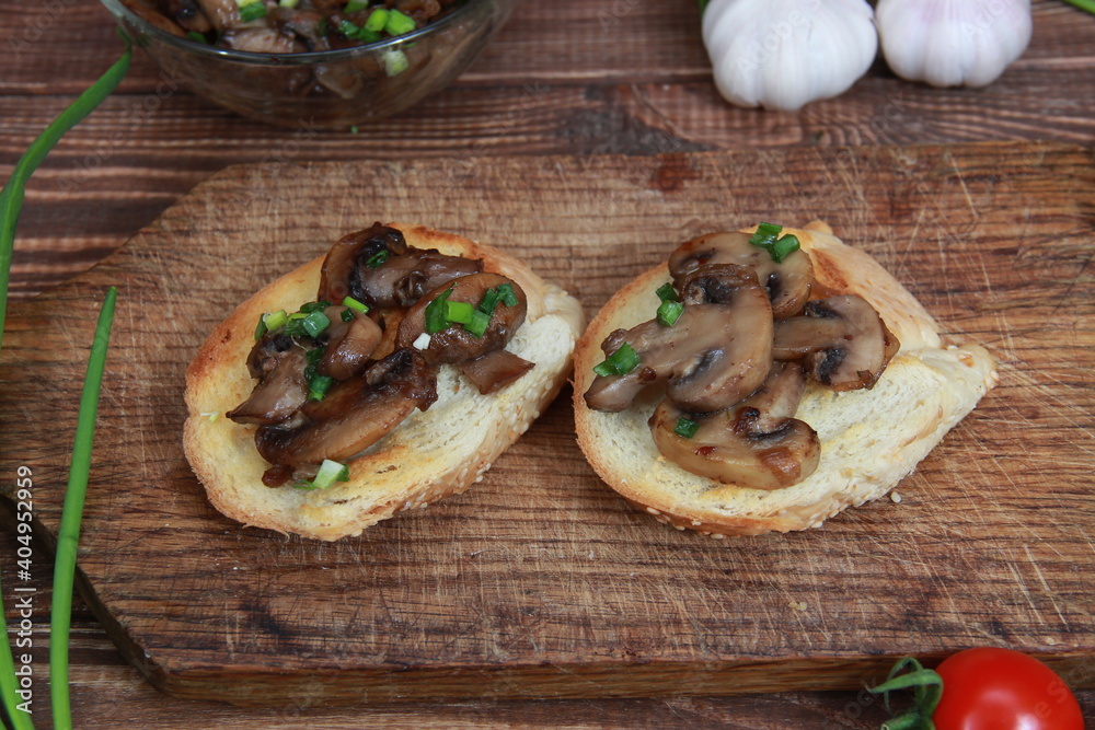 fried croutons with mushrooms and green onions close-up on a wooden table