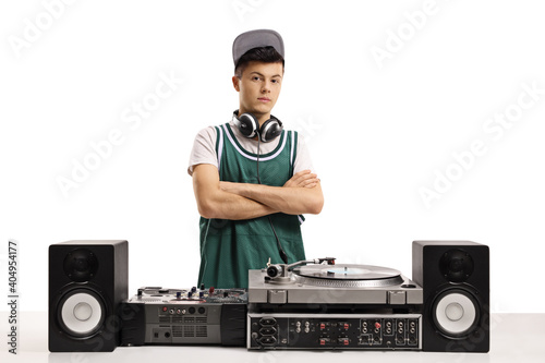 Young male dj with vinyl turntable posing with crossed arms