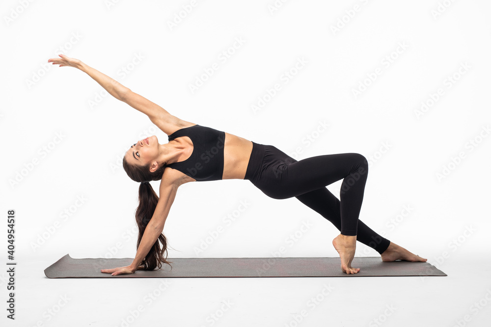 Sporty young woman doing yoga practice isolated on white background. Concept of healthy life and natural balance between body and mental development