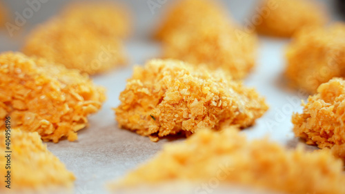 Chicken nuggets on parchment paper before baking.