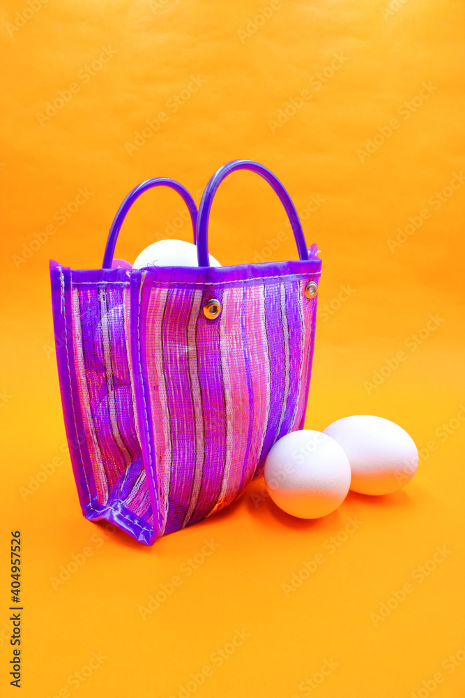 Bag to go to the market, sent or super Mexican style, with white eggs inside, on an orange background Bag to go to the market, sent or super Mexican style, with white eggs inside, on an orange background