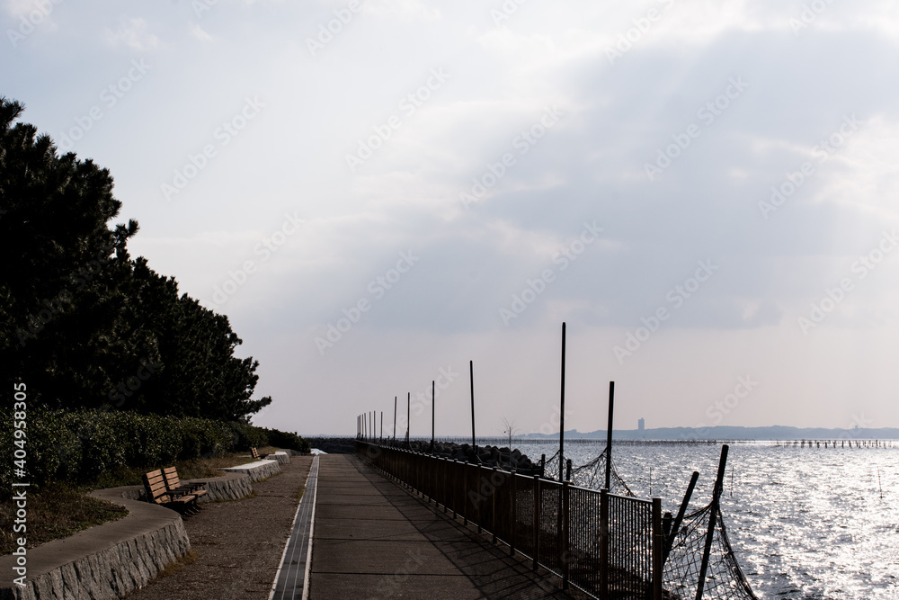 Path and bench along the quay in Isshiki, Nishio City, Aichi Prefecture, under clear skies.