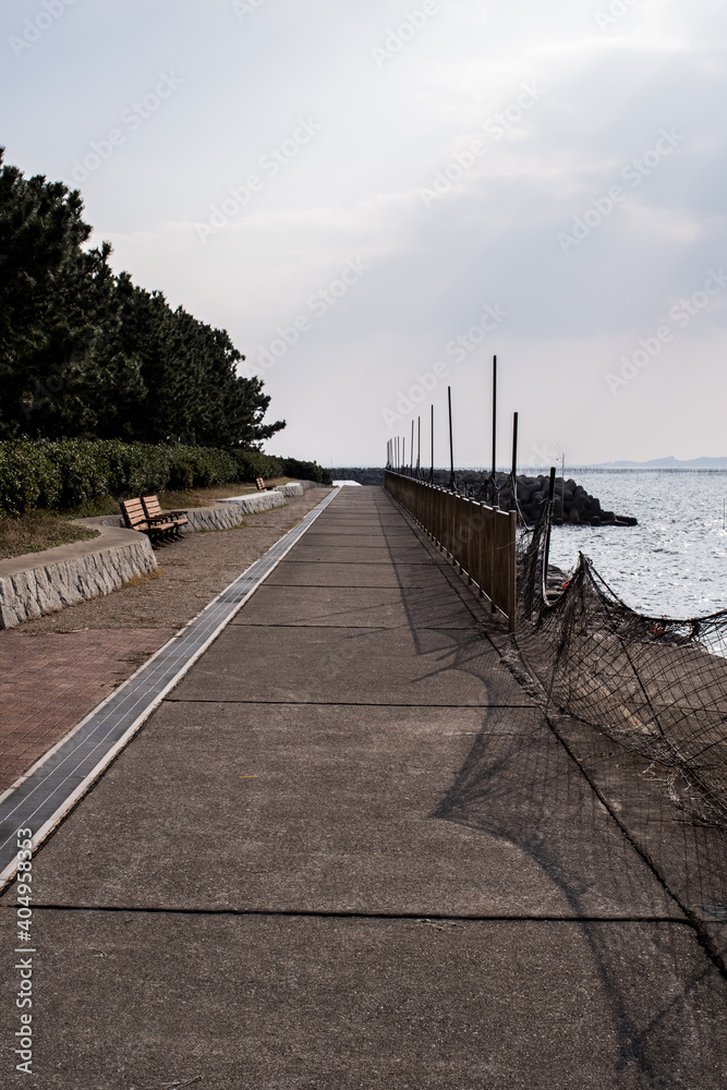 Path and bench along the quay in Isshiki, Nishio City, Aichi Prefecture, under clear skies.