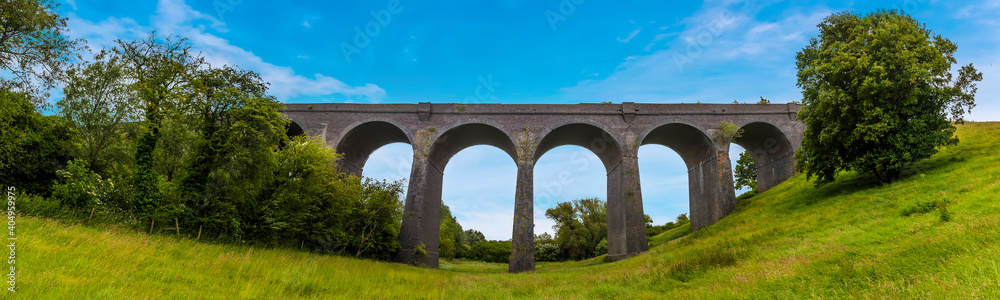 A panorama view from the valley floor of the northern side of the derelict and abandoned viaduct near Catesby, Northamptonshire, UK