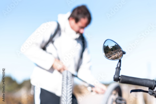 Man repairing mountain bike wheel, unfocused image.