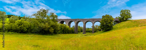 A panorama view along the valley floor of the northern side of the derelict and abandoned viaduct near Catesby, Northamptonshire, UK photo