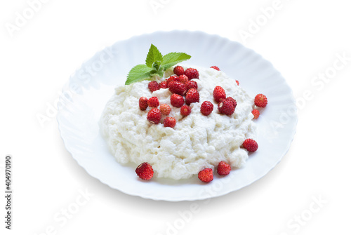 Plate with cottage cheese, wild strawberries and mint on a white background
