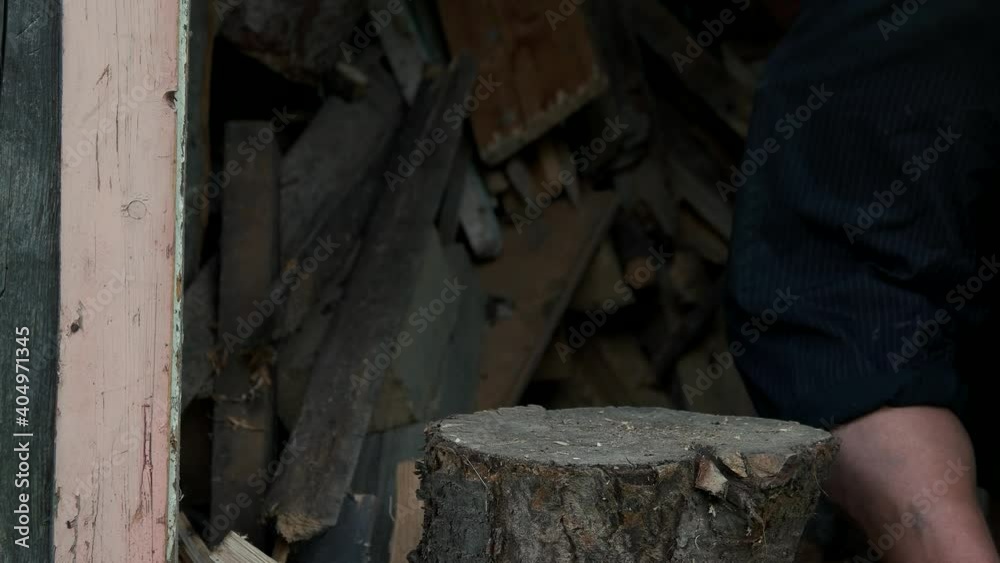 Man chopping wood with an axe. Farmer with an axe chopping wood in the barn.