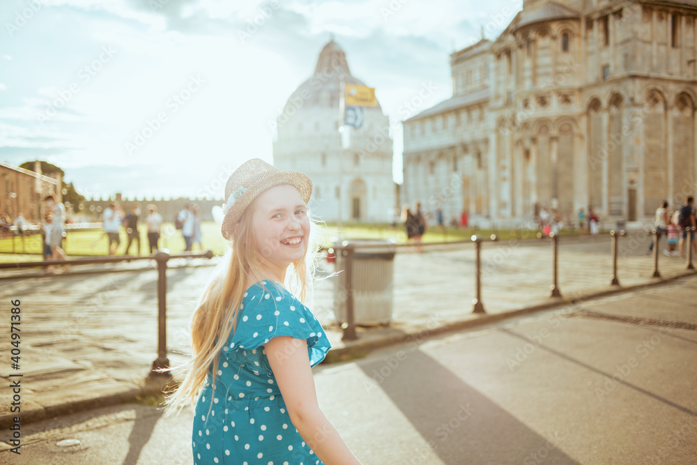 smiling modern girl in blue overall and hat sightseeing
