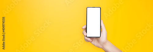 concept - cell phone in a man's hand on yellow background
