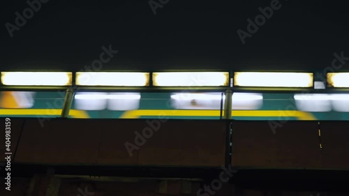 Metro train travel at night. Illuminated bridge. Blue-blue train.