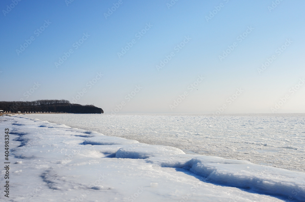 Frozen winter beach with frozen blocks of ice on the shore. Frozen winter beach with frozen blocks of ice on the shore.