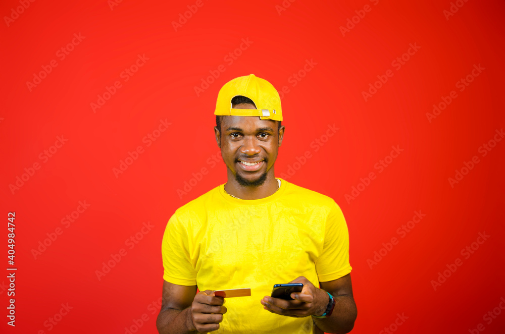 handsome young african man using his credit card to bills online