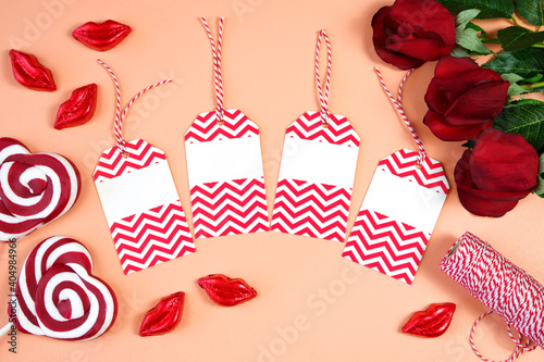 Fotografía Happy Valentine's Day gift hang tag labels, styled with Valentine red roses, heart shape gift and lipstick kissess chocolates on a modern coral background