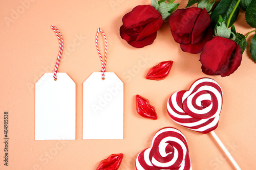 Cuadro en lienzo Happy Valentine's Day gift hang tag labels, styled with Valentine red roses, heart shape gift and lipstick kissess chocolates on a modern coral background