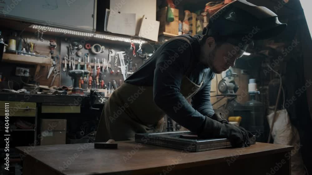A welder in a protective suit puts the parts in the correct position A welder in a protective suit puts the parts in the correct position