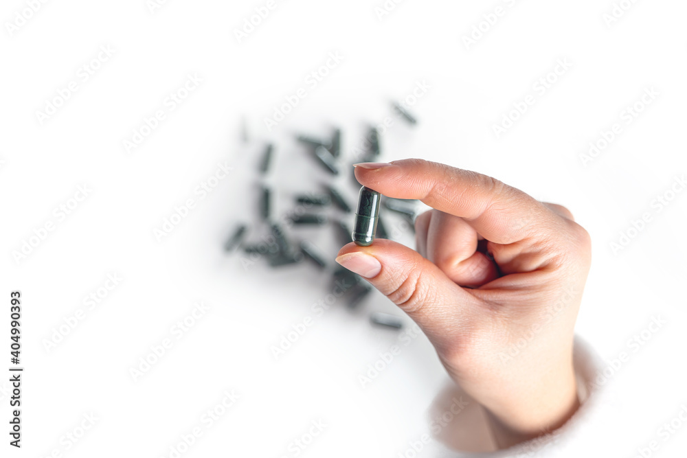 treatment and prevention of diseases, spirulina, capsules with green powder in hand on white treatment and prevention of diseases, spirulina, capsules with green powder in hand on white