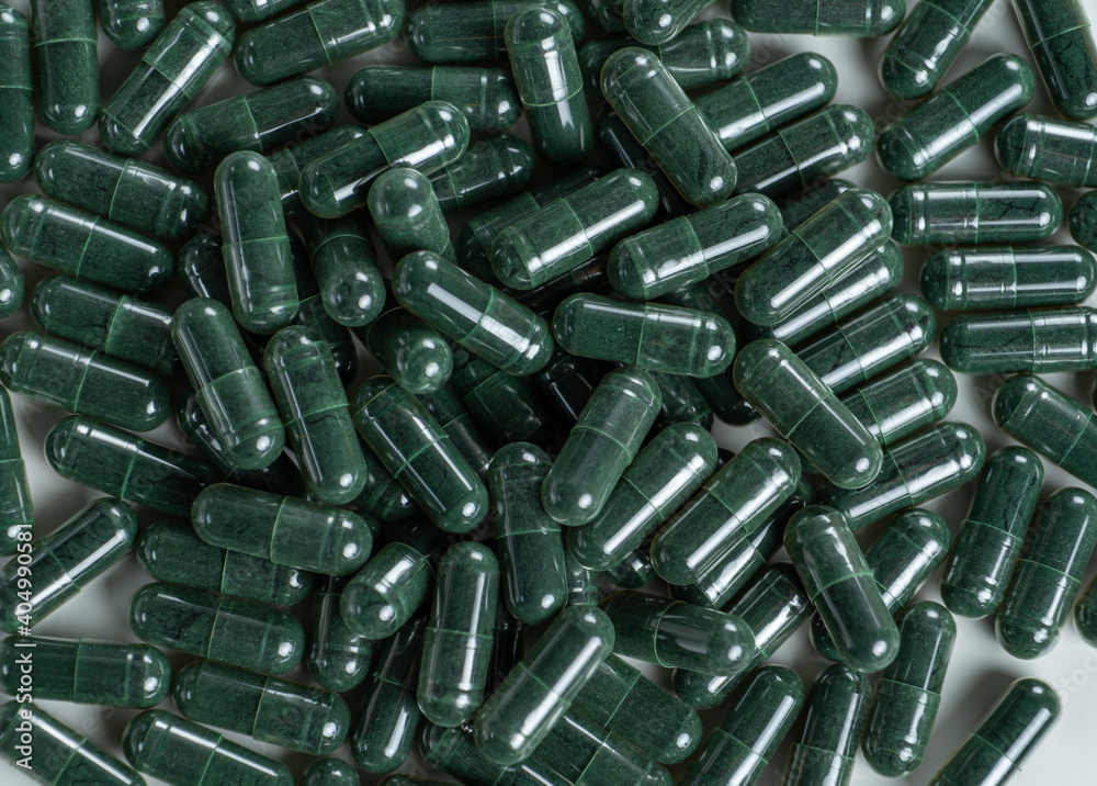treatment and prevention of diseases, spirulina, capsules with green powder on white treatment and prevention of diseases, spirulina, capsules with green powder on white