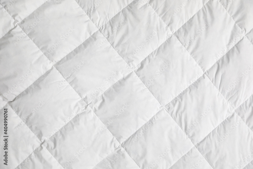 Foto Soft quilted blanket as background, top view