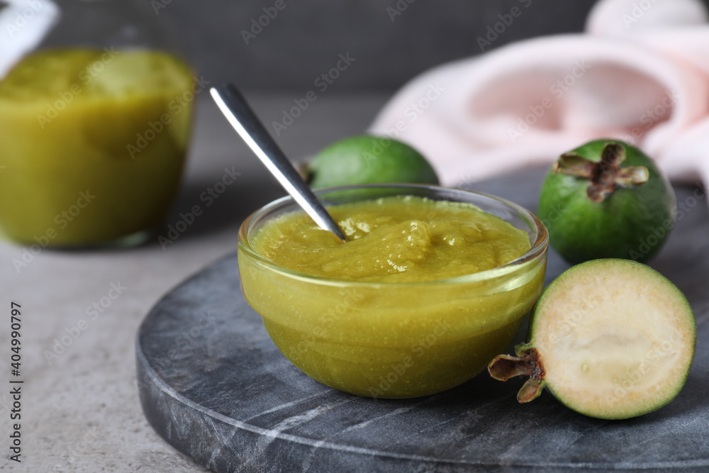 Feijoa jam and fresh fruits on grey table, closeup Feijoa jam and fresh fruits on grey table, closeup