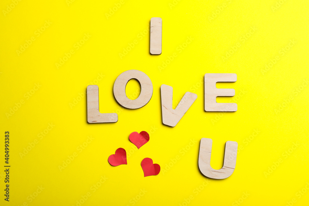 Phrase I Love You made of wooden letters on yellow background, flat lay Phrase I Love You made of wooden letters on yellow background, flat lay