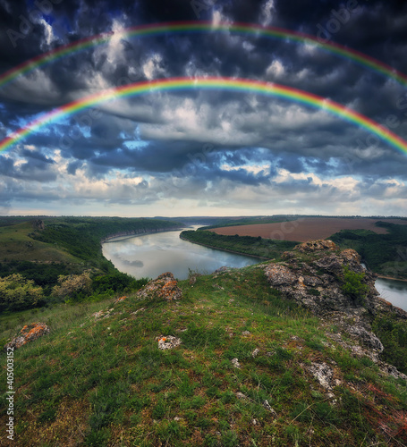 colorful rainbow over the river canyon. spring morning