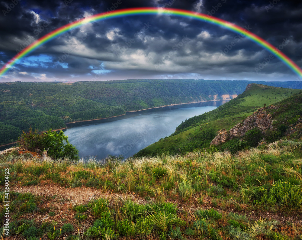 Obraz premium colorful rainbow over the river canyon. spring morning