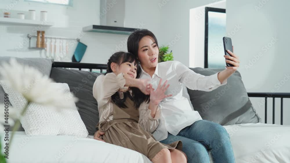 Asian young mother and daughter making video call with her husband. Asian young mother and daughter making video call with her husband.