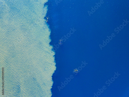 Aerial view of a fisherman fishing in the mouth of the muddy Comoro river with the green coral reef ocean in Dili, Timor-Leste. photo