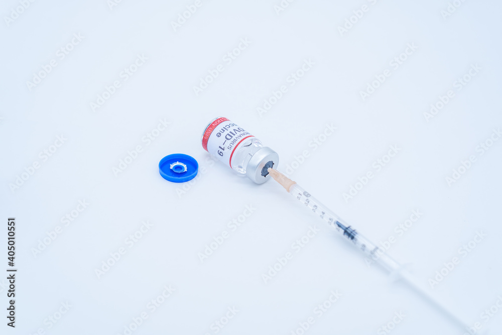A medical syringe is inserted into the COVID-19 vaccine bottle