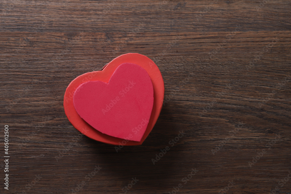 Red heart-shaped gift box on wooden background with space Red heart-shaped gift box on wooden background with space