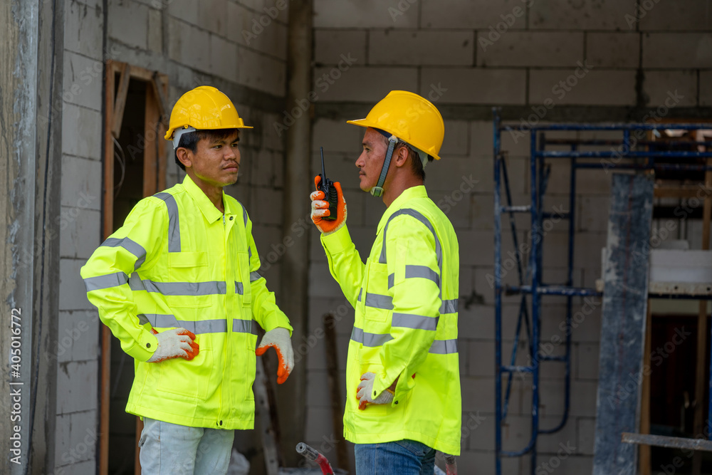 Construction worker wearing safety clothing and discussing on construction site. Construction worker wearing safety clothing and discussing on construction site.