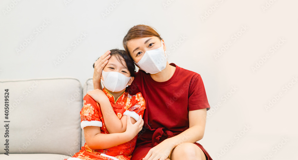 Happy chinese new year.Asian mother and kid girl wearing mask and chinese traditional cheongsam dress.Social distance wear mask, Health insurance, covid19, lockdown.stay home.medical Mask healthcare.