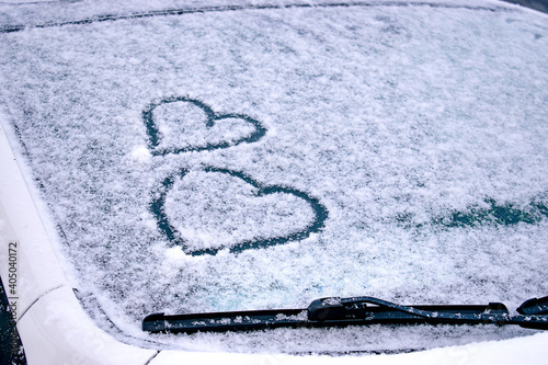 Finger-drawn hearts on the snow-covered windshield of a car.Valentine's Day concept.Copy space for text. © Tatyana