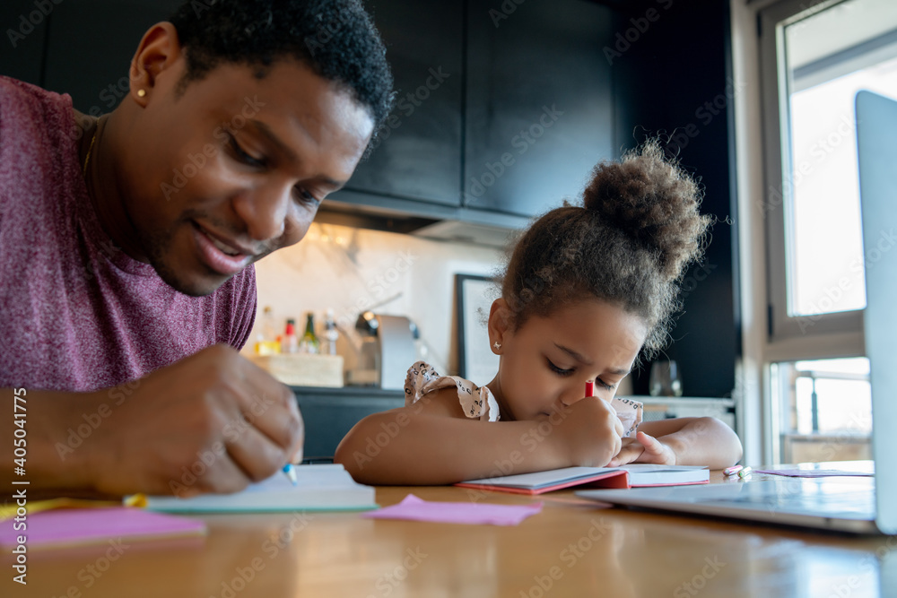 A father helping his daughter with homeschool. A father helping his daughter with homeschool.