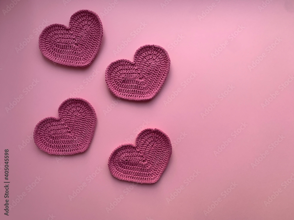 Knitted pink hearts on a pink background.Photo from above. The concept of creating a product. Crocheting. Valentine's Day concept