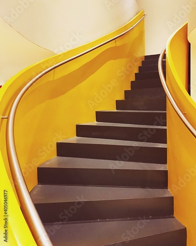Brown wooden staircase with yellow railings photo