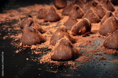 Fototapeta Naklejka Na Ścianę i Meble -  Chocolate truffles with cocoa powder on a black background