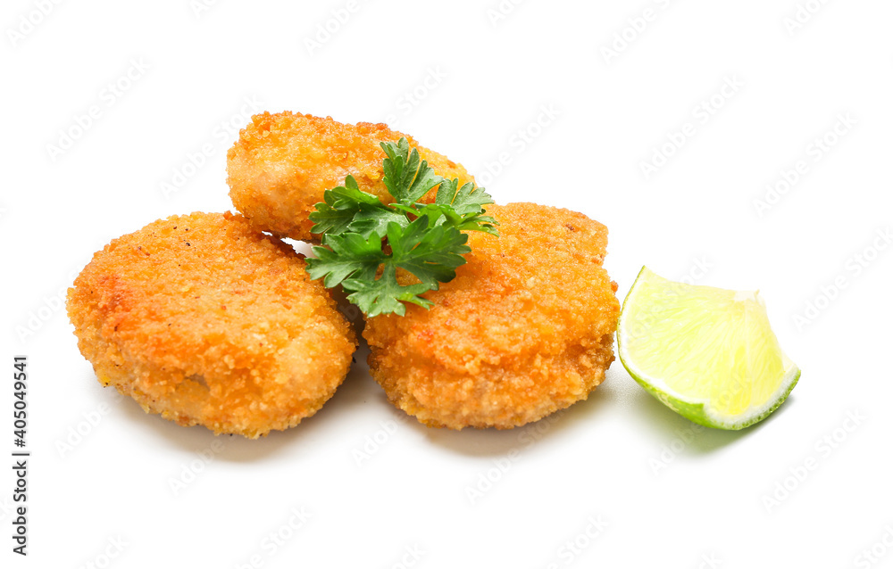 Tasty nuggets and lime on white background