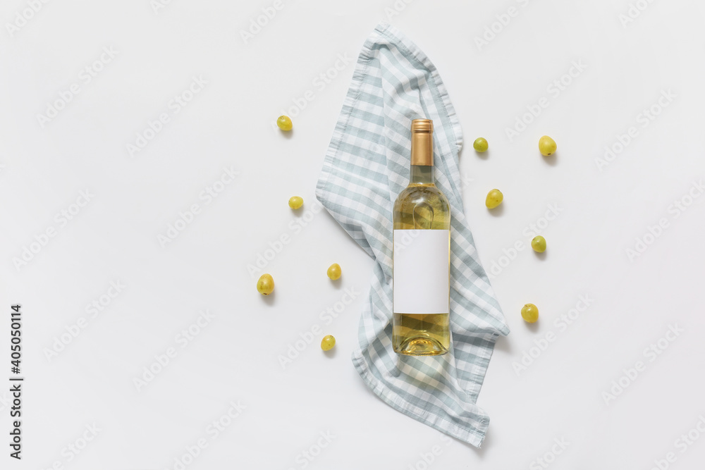 Fototapeta premium Bottle of wine with blank label, napkin and grapes on white background