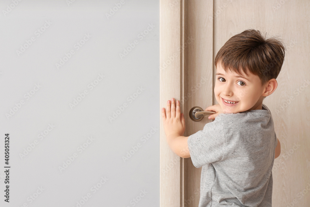 Cute little boy standing near closed door Cute little boy standing near closed door
